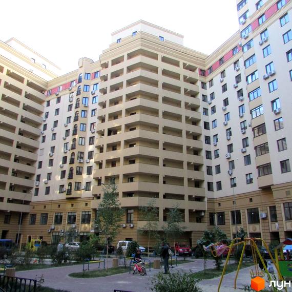 Житловий комплекс Златоустівський з балконами та кондиціонерами. На прибудинковій території дитячий майданчик та дерева.