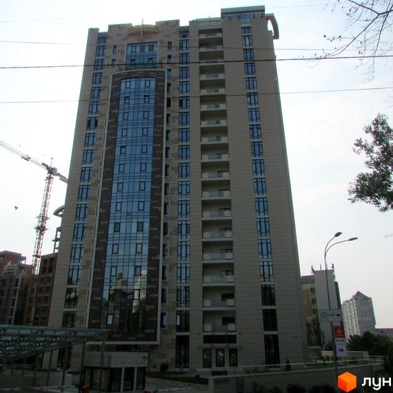 Житловий комплекс Бульвар Фонтанів з фасадом з великими вікнами. Прибудинкова територія з озелененням та паркінгом.