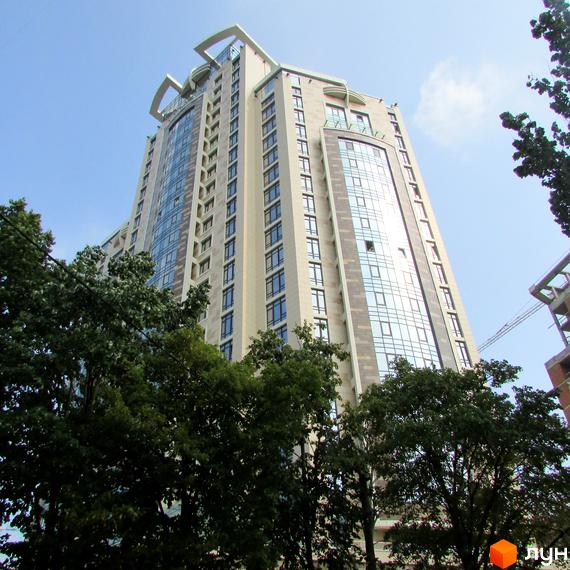 Житловий комплекс Бульвар Фонтанів з високими вікнами та сучасним фасадом, оточений зеленими насадженнями.