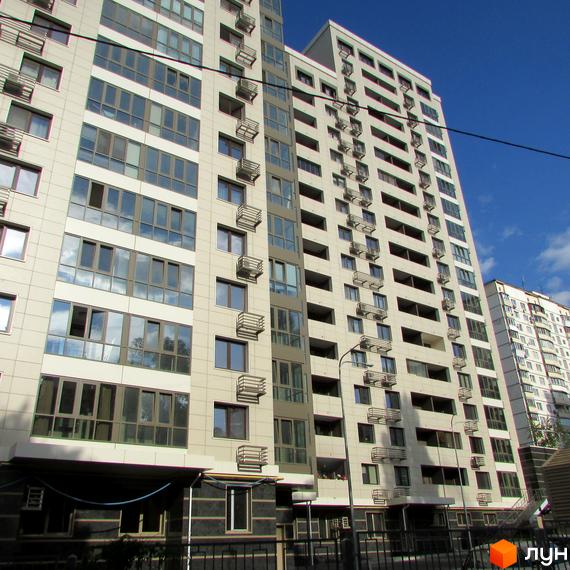 Зовнішній вигляд новобудови ЖК Островського, 40, з численними вікнами та балконами. На передньому плані видно огорожу та частину прибудинкової території.