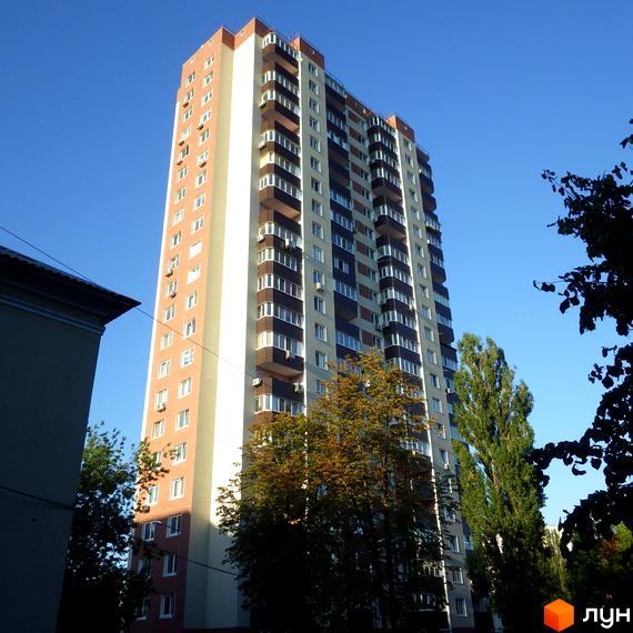 Житловий комплекс Будинок на Шулявці, висотна будівля з балконами та зеленими насадженнями на прибудинковій території.