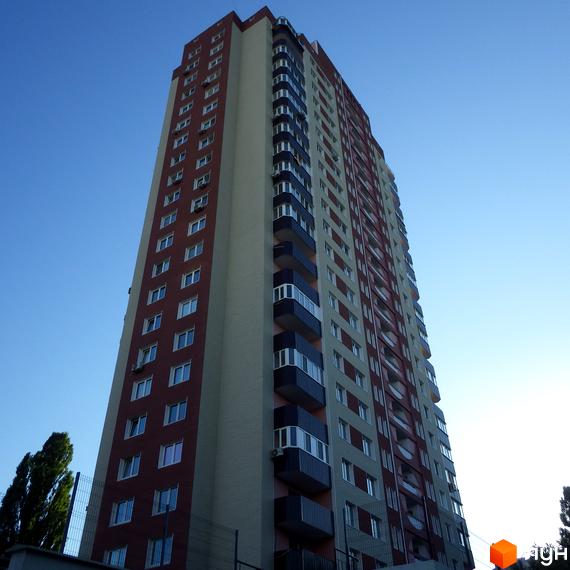 Житловий комплекс Будинок на Шулявці, висотна будівля з балконами та вікнами. Прибудинкова територія з зеленими насадженнями.