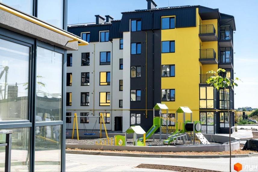 Житловий комплекс Італійський з яскравим фасадом та дитячим майданчиком. Сучасна новобудова з великими вікнами та балконами.