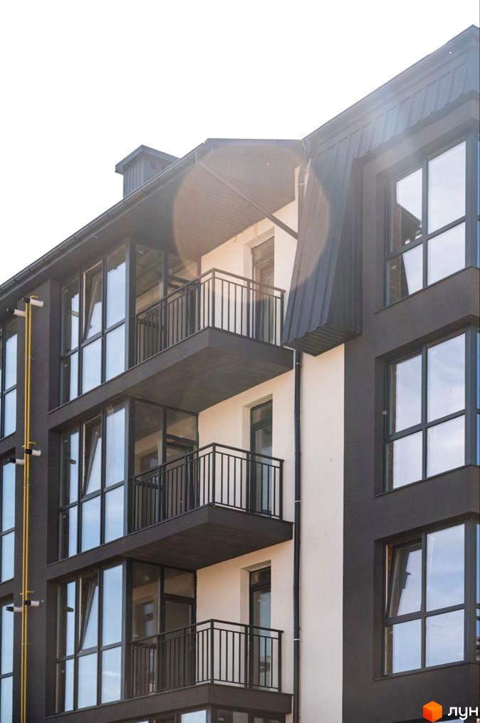 Фасад житлового комплексу Італійський з балконами та великими вікнами.