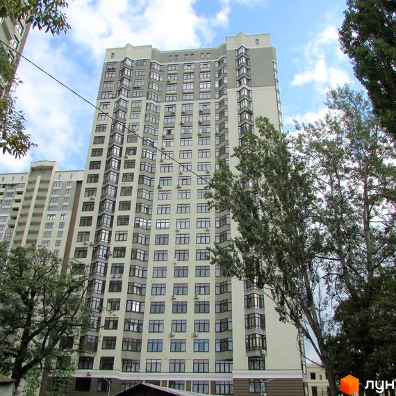 Зовнішній вигляд новобудови ЖК Зелений острів-2. Багатоповерховий будинок з сірими та білими фасадами, великою кількістю вікон та балконів.