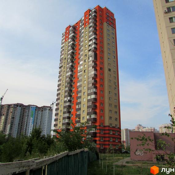 ЖК на Григоренка, 12а: висотний будинок з помаранчевим та світло-бежевим фасадом, балконами. Навколо зелень та інші забудови.