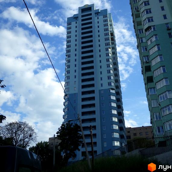 Житловий комплекс на вул. Феодосійській, 2 (є, ж, з, і). Високі багатоповерхові будинки блакитного та зеленого кольорів, оточені зеленню та деревами.