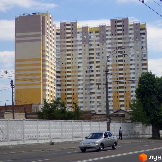 Житловий комплекс просп. Науки, 55а. Багатоповерхові будинки з жовто-сірою фасадною обробкою та численними вікнами. Поруч дорога, тротуар та зелені насадження.