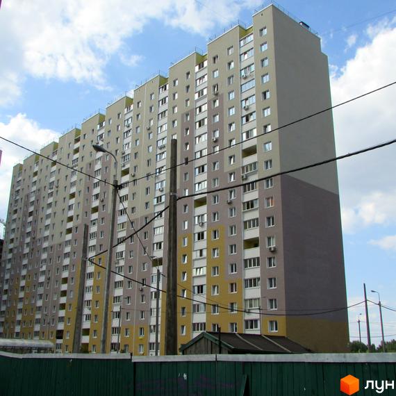 Житловий комплекс Милославичі з висотними будинками та прибудинковою територією. Вид на фасад з вікнами та балконами.