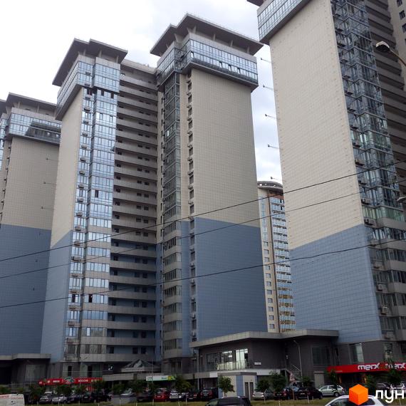 Житловий комплекс RiverStone. Багатоповерхові будинки з панорамним склінням та сірими фасадами. Навколо новобудов розташовані автомобілі та дерева.