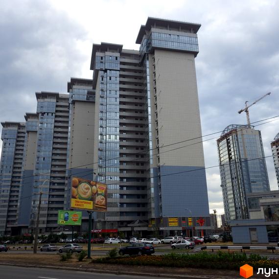 Житловий комплекс RiverStone - це сучасні багатоповерхові будинки з панорамними вікнами та балконами. Навколо комплексу розташовані дороги та зелені насадження.