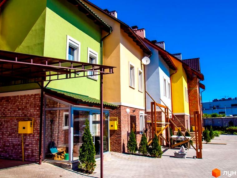 Яскраві таунхауси ЖК Polish Corner з цегляними фасадами та зеленими дахами, з облаштованою прибудинковою територією.