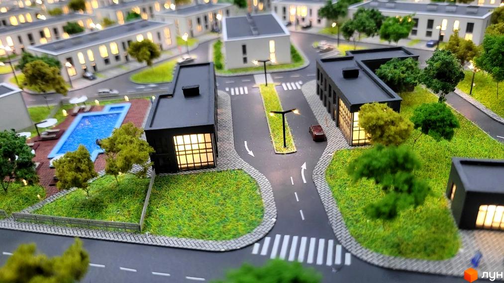Таунхауси DREAM HOUSE: макет комплексу з темними будинками, великими вікнами, басейном та доріжками. Навколо багато зелені.