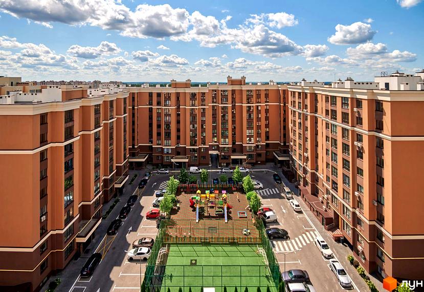 Житловий комплекс Софіївські Липки з коричневими фасадами та зеленою прибудинковою територією з дитячим майданчиком та спортивним полем.