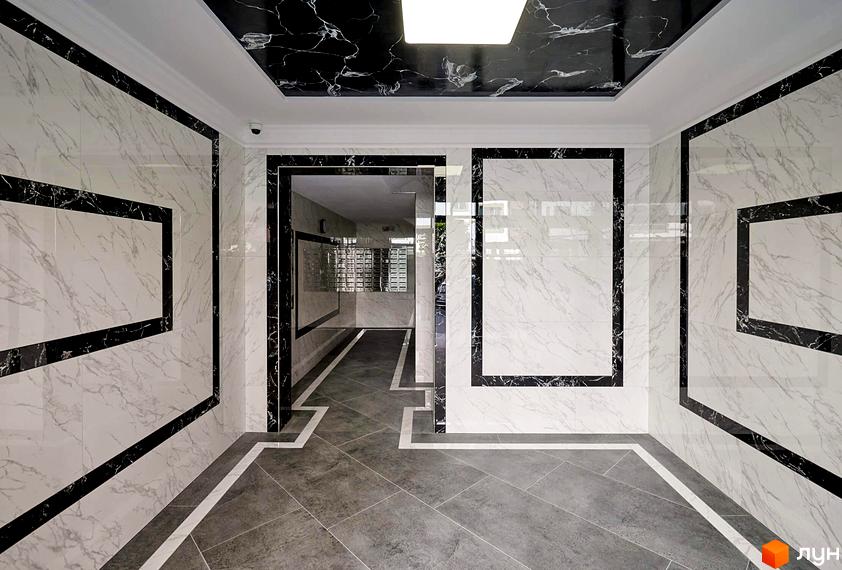 Сучасний дизайн холу новобудови ЖК Софіївські Липки з мармуровим оздобленням стін та підлоги. Просторий вхід з поштовими скриньками.