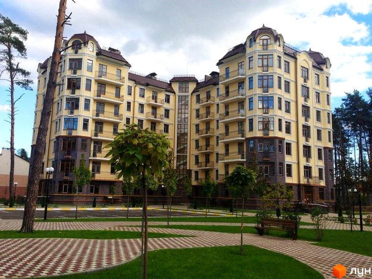 Житловий комплекс Rich Town з фасадом у світлих тонах та великими вікнами, прибудинкова територія з зеленими насадженнями та доріжками.
