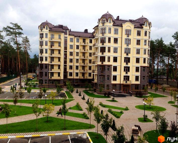 Житловий комплекс Rich Town з просторою прибудинковою територією. Багатоквартирний будинок з балконами та великими вікнами, виконаний у світлих тонах.