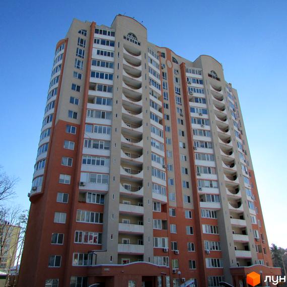 Багатоповерховий житловий комплекс Берізки з фасадом бежевого та помаранчевого кольорів, численними вікнами та балконами. Навколо будівлі видно дерева.