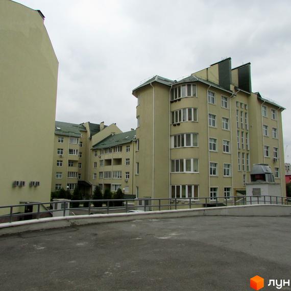 Житловий комплекс Петропавлівський: світлі багатоповерхові будинки з зеленими дахами та прибудинковою територією з парковкою.