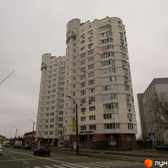 Житловий комплекс Оваціо з сучасним фасадом та прибудинковою територією. Вид на будинок з вулиці, автомобілі на дорозі.