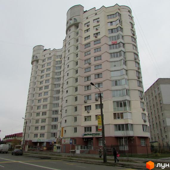 Житловий комплекс Оваціо з сучасним фасадом та просторою прибудинковою територією, облаштованою для відпочинку.