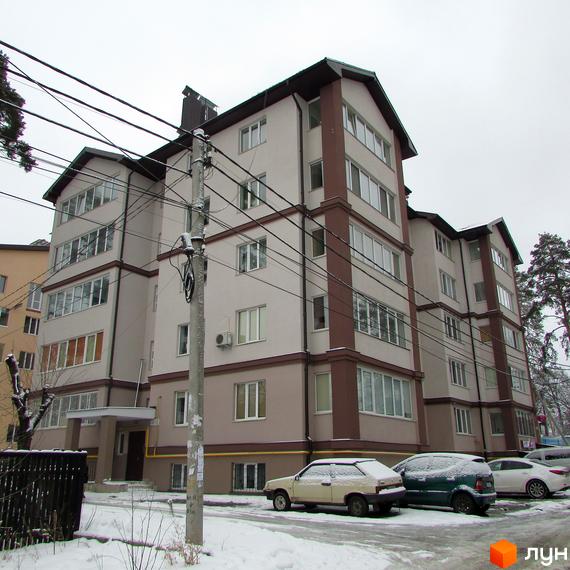 Житловий комплекс на вул. Виговського, 22, 22а, з фасадом та прибудинковою територією, покритою снігом.