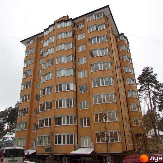 Житловий комплекс ЖК Суворов з багатоповерховим цегляним будинком та прибудинковою територією з деревами.