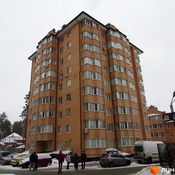 Житловий комплекс ЖК Суворов з цегляною фасадною стіною та великими вікнами. Прибудинкова територія з автомобілями та пішоходами.
