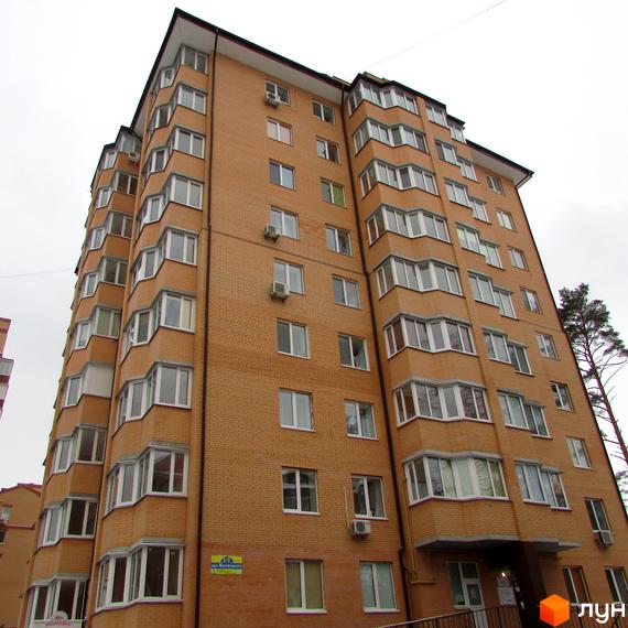 Житловий комплекс ЖК Суворов з цегляною фасадною стіною та великими вікнами. Прибудинкова територія з зеленими насадженнями та зручним входом.