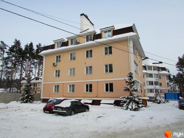 Житловий комплекс Матросова. Зовнішній вигляд багатоповерхового будинку з жовтою фасадною штукатуркою та коричневим дахом. Прибудинкова територія вкрита снігом, стоять автомобілі.
