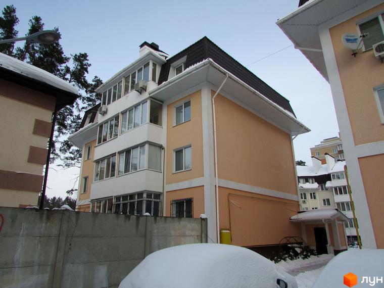 Житловий комплекс Матросова. Зовнішній вигляд багатоповерхового будинку з балконами та вікнами. Навколо будинку видно дерева та засніжену територію.