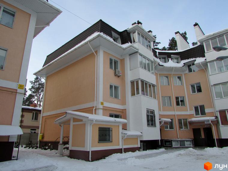 Житловий комплекс Матросова - зовнішній вигляд будинку з коричневим дахом та світло-бежевими стінами, розташований на засніженій території.