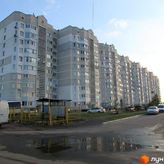 Житловий комплекс Петрівський оновлений з фасадом та прибудинковою територією. Вид на будинок з парковкою та зеленими зонами.