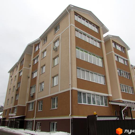 Зовнішній вигляд багатоповерхового будинку житлового комплексу Квартал на Київській. Фасад оздоблений світло-бежевими та коричневими панелями, багато вікон. Навколо будинку видно елементи прибудинкової території.