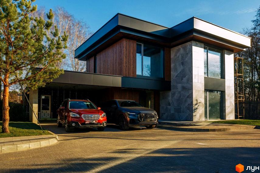 Котеджне містечко MAREA CLUB ROMANKIV. Сучасний двоповерховий будинок з великими вікнами та дерев'яними елементами, два автомобілі на вимощеному подвір'ї.