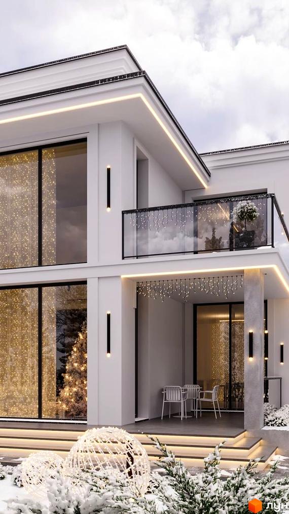 Котеджне містечко Затишна Солонка: білий двоповерховий будинок з панорамними вікнами та підсвіткою. Прибудинкова територія прикрашена зимовими гірляндами та снігом.