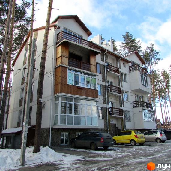 Житловий комплекс Островський - це багатоповерхова новобудова з балконами та панорамними вікнами. Перед будинком розташована парковка з кількома автомобілями.