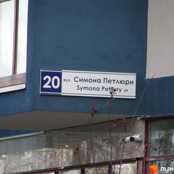 Будинок ЖК Фамільний з вивіскою вулиці Симона Петлюри, 20. На фасаді видно вікно та елементи зовнішнього оздоблення.