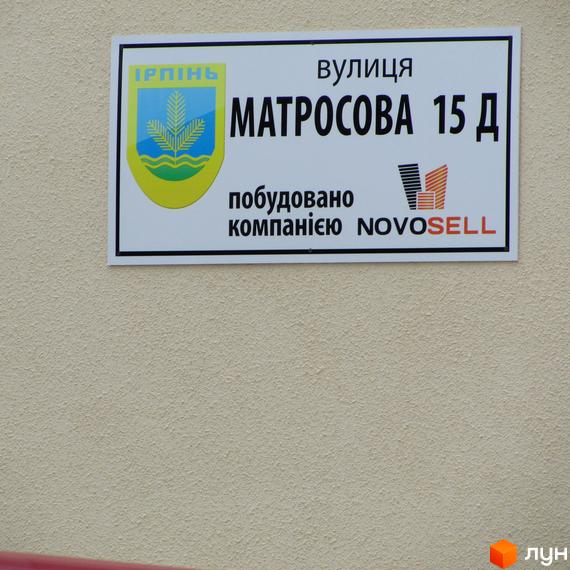 Фасадна табличка житлового комплексу Matroskin з адресою вулиця Матросова 15 Д, Ірпінь, та інформацією про забудовника NovoseLL.