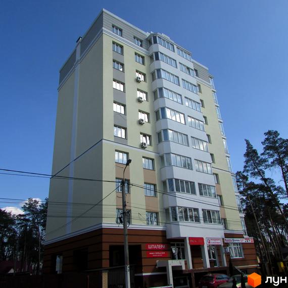 Зовнішній вигляд житлового комплексу Капітал з великою кількістю вікон та балконів. Будинок має світло-жовтий фасад та коричневий цоколь. Навколо ростуть дерева.