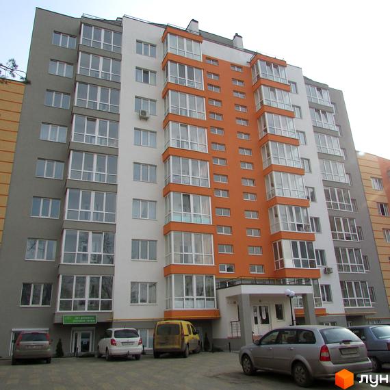 Житловий комплекс Status - багатоповерхова новобудова з білими та помаранчевими фасадами, великою кількістю скління та прибудинковою територією з автомобілями.