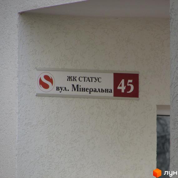 Житловий комплекс Status, вул. Мінеральна, 45. Зовнішній вигляд фасаду будівлі з вивіскою.