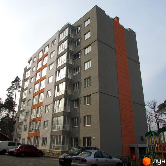 Житловий комплекс Status – це сіра багатоповерхівка з помаранчевими акцентами та великою кількістю вікон. Біля будинку є парковка та дитячий майданчик.