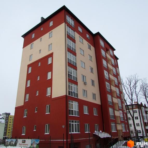 Висотна новобудова ЖК Green Life з червоними та бежевими фасадами. На території комплексу є огорожа та реклама.