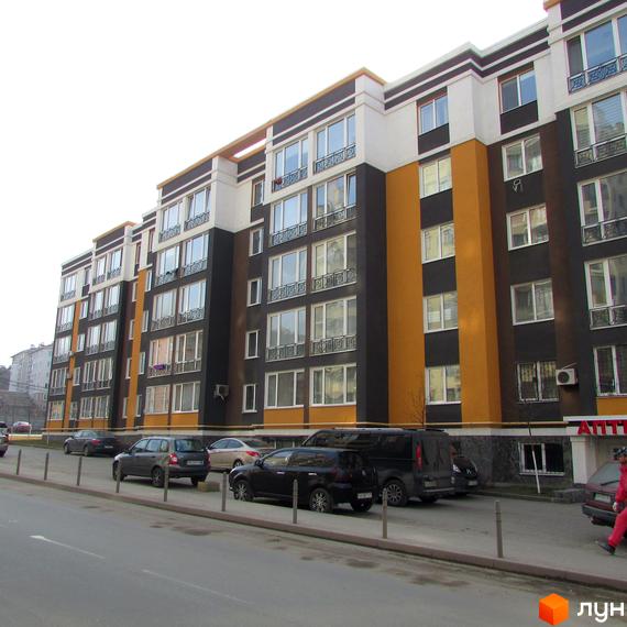 Житловий комплекс Фортуна-2. Багатоповерховий будинок з великою кількістю вікон. На вулиці припарковані автомобілі.