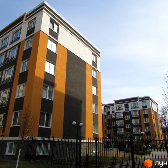 Зображення сторінки житлового комплексу Фортуна-2. Багатоповерхові будинки з жовто-чорними фасадами та білими верхніми поверхами. Територія огороджена металевим парканом.