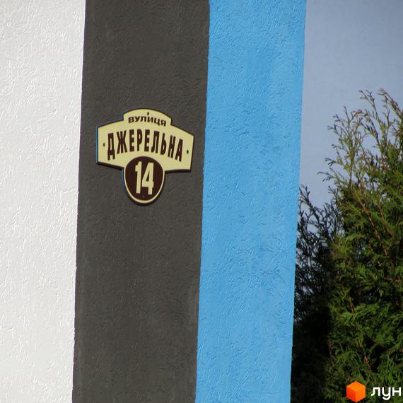 Фасад будинку ЖК Фортуна-2 з табличкою з номером 14. Навколо будинку зелені насадження.