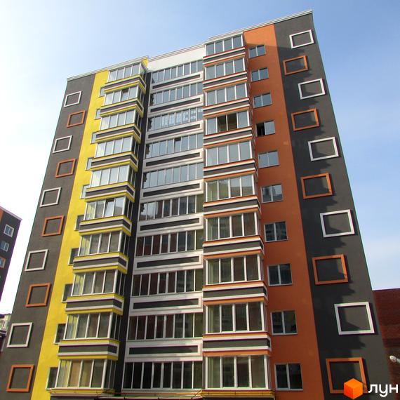 Висотна будівля ЖК Синергія-2 з яскравим фасадом. На фасаді видно вікна та декоративні елементи, що додають архітектурної виразності.