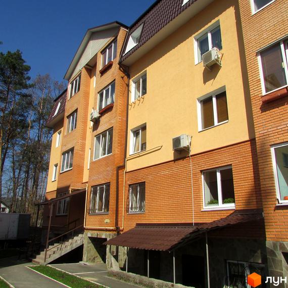 Зовнішній вигляд новобудови на вул. Полтавська, 31е, 31з, з цегляним та жовтим фасадом, вікнами та кондиціонерами. Поруч сходи та навіси.