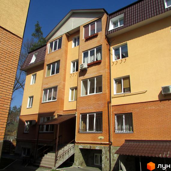 Житловий комплекс на вул. Полтавська, 31е, 31з. Будинок з жовтою та цегляною обробкою, вікнами та кондиціонерами. Біля будинку є сходи та навіс.